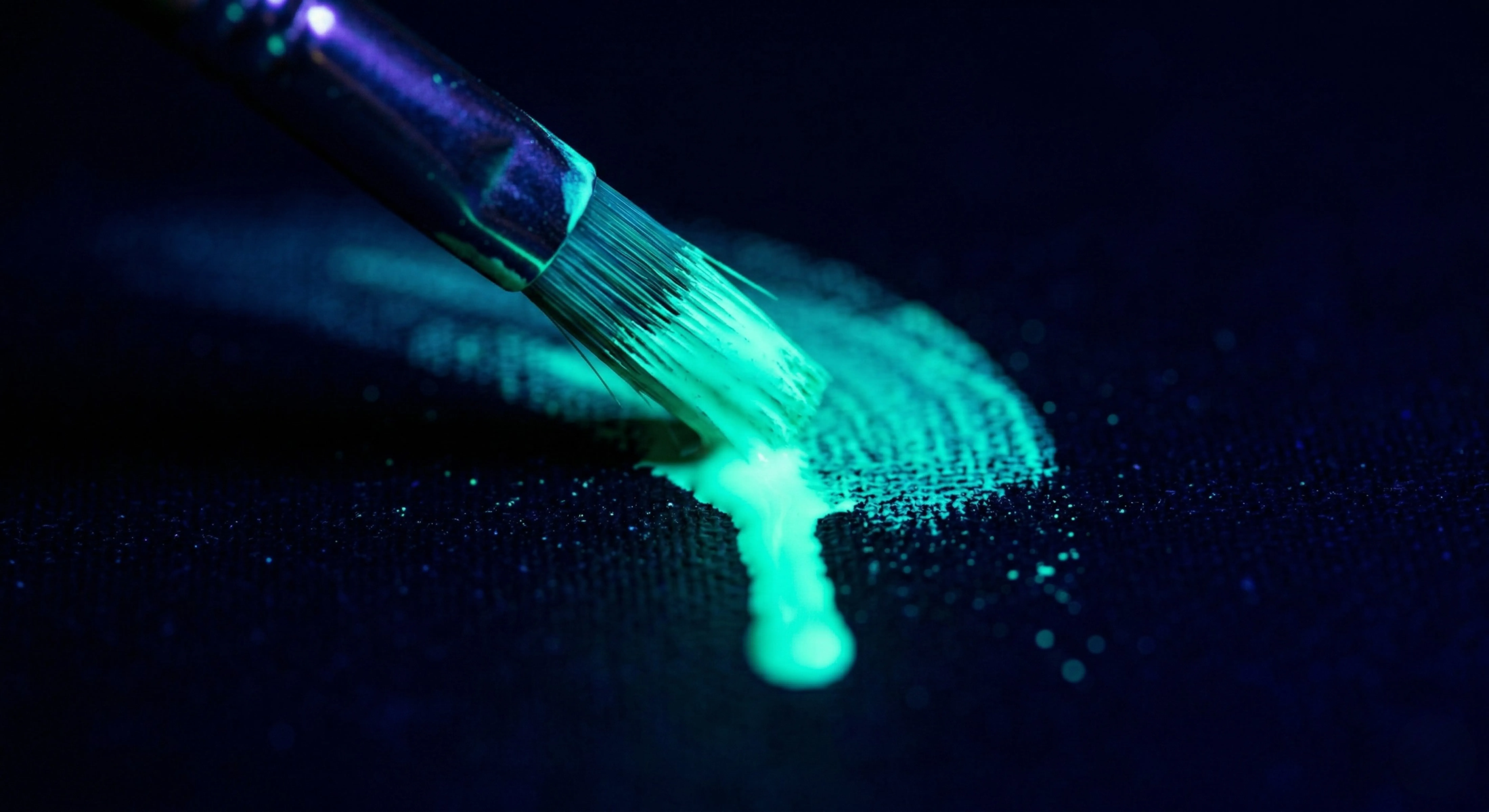 Neon paint brush glowing under blacklight