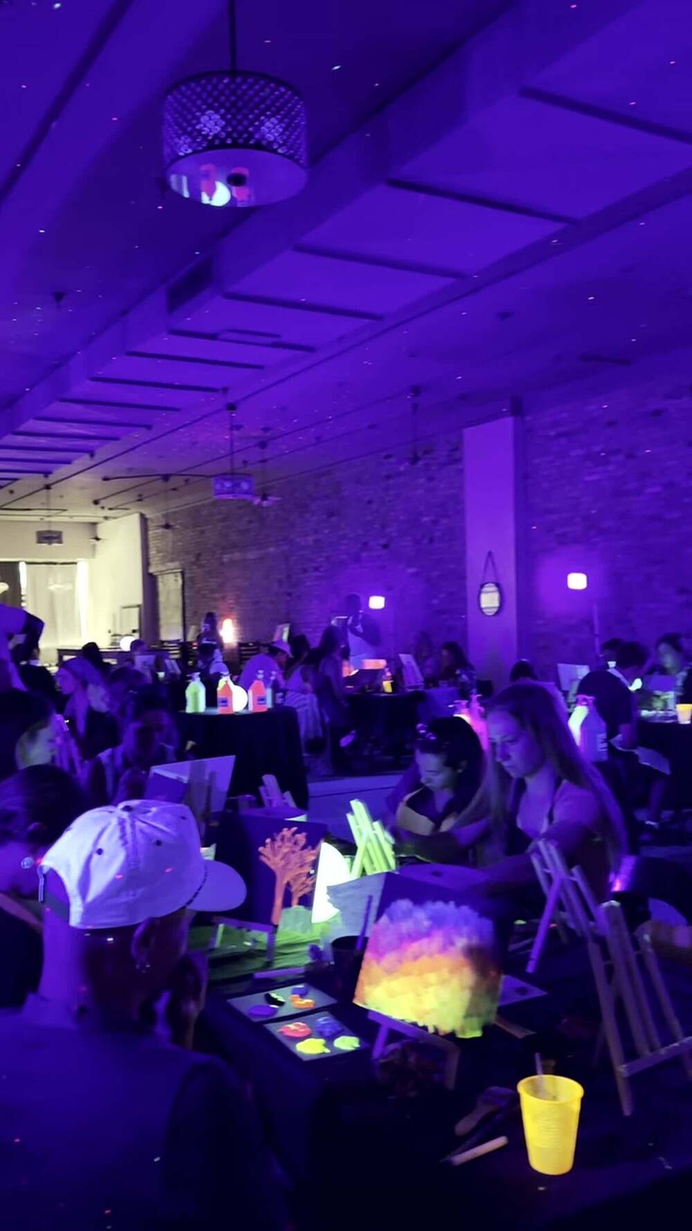 Palettes of neon paint glowing on a table under ultraviolet light